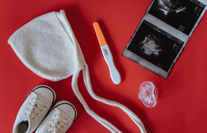 cosas de bebé: test de embarazo, ecografía, gorrito, zapatillas, chupete nombres neutros para bebés