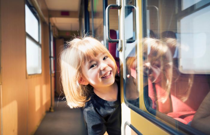 Niños sonriente que viaja solo en tren Niños que viajan solos en tren