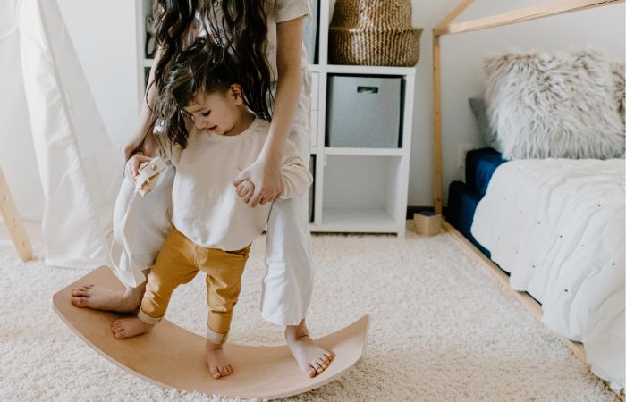 niño con su madre sobre tabla de equilibrio de madera tabla de equilibrio