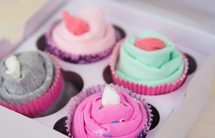 ropa para bebé presentada para que parezcan cupcakes ropa para bebé doblada como cupcake