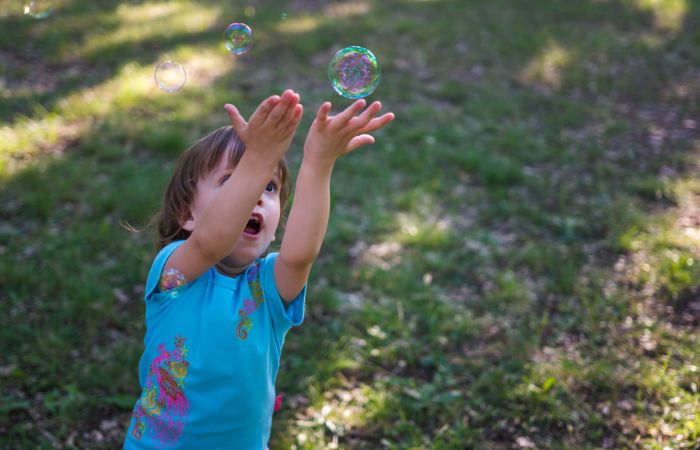 Usa las pompas para fomentar el dominio de los niños Atrapando pompas de jabón