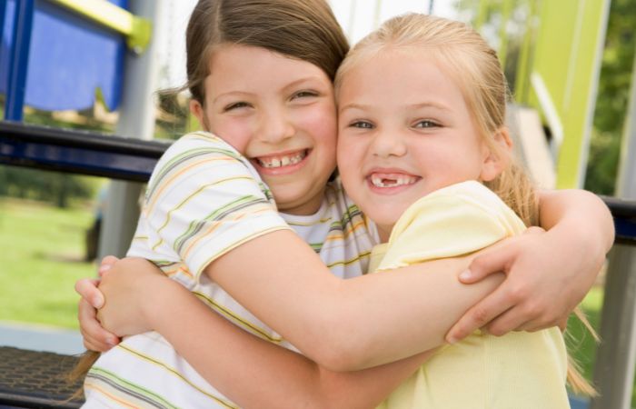 dos niñas se abrazan alegres demostrando empatía Trabajar la empatía: alegrarse de las alegrías de otro