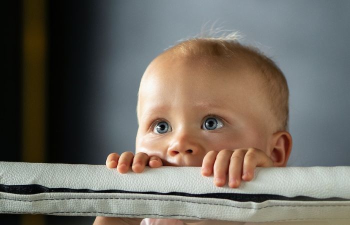 Bebé asomado a su cuna cunas para bebés