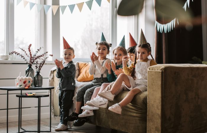 Festejo de cumpleaños: niños con gorritos de papel aplaudiendo Celebración para niños
