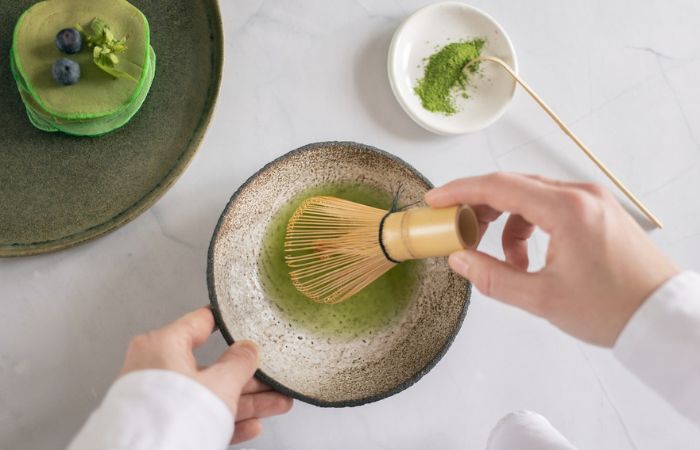 Proceso de batir el polvo verde con batidor de bambú polvo verde para infusión