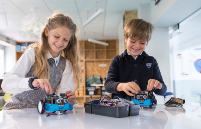 Niña y niño en clase de robótica ISP Schools clases de robótica