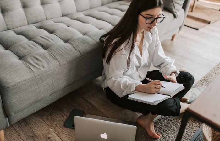 mujer escribiendo en un bloc de notas dispositivos para escribir reutilizables
