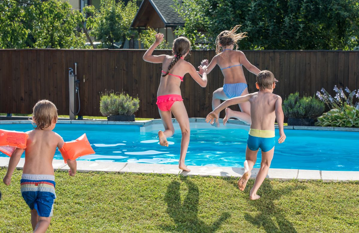 Niños tirándose al agua para jugar al tiburón Juegos de piscina: tiburón