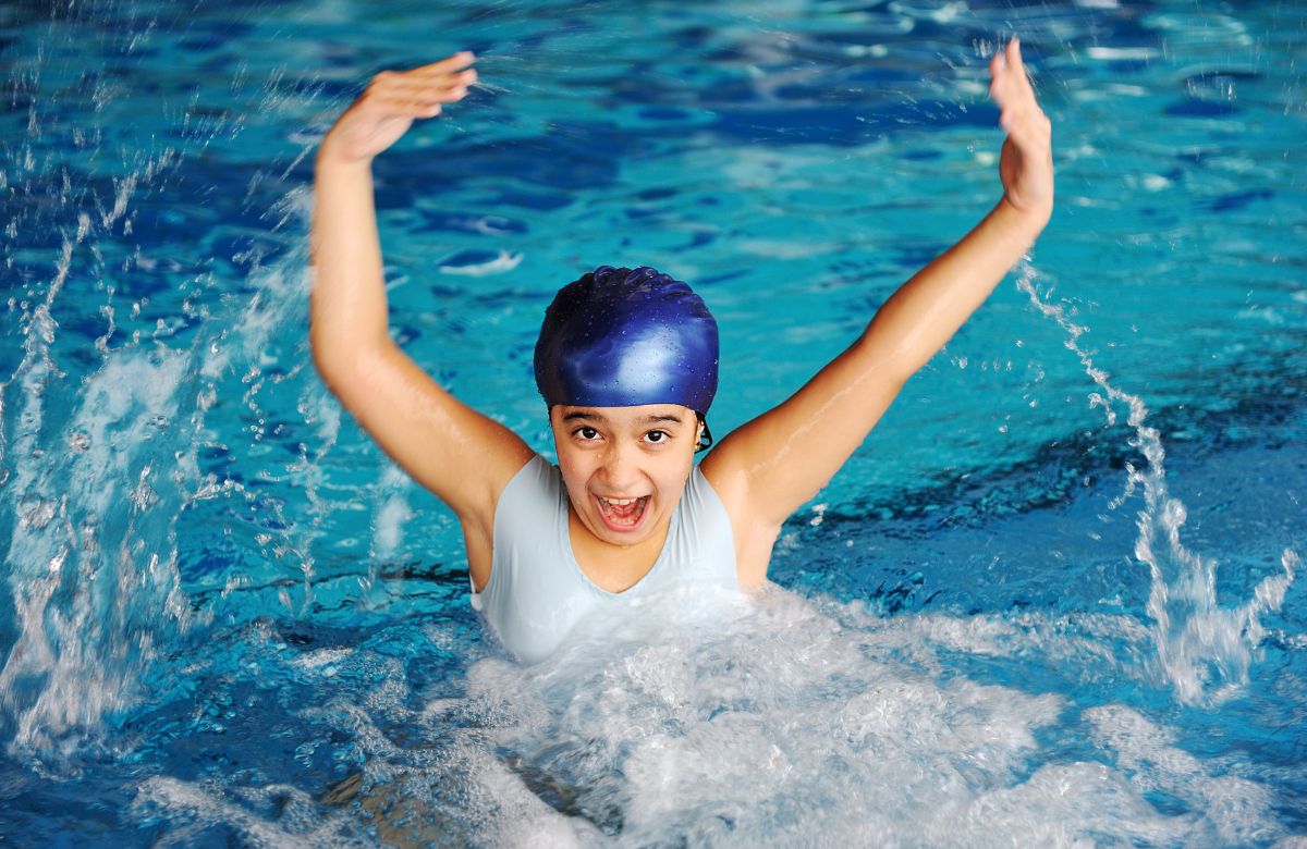 niña jugando en el agua con gorro de natación Waterpolo
