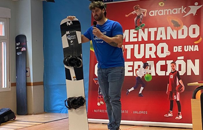 Lucas Eguibar dando una charla en un colegio sujetando una tabla de snowboard Aramark: Lucas Eguibar habla a los niños de su disciplina deportiva