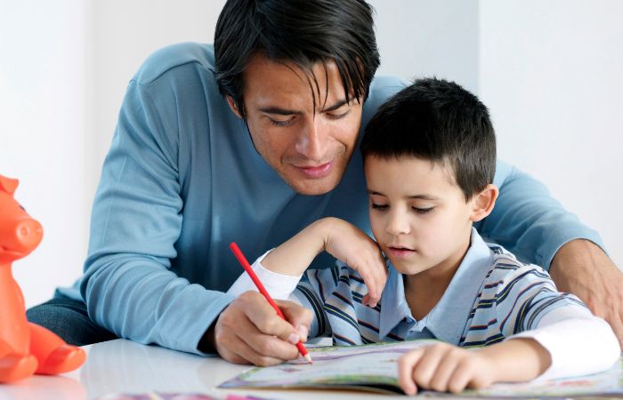 Padre haciendo la tarea de su hijo Sobreprotección infantil: hacer las tareas de los niños por ellos