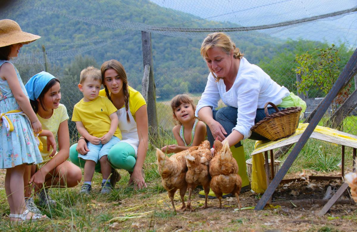 Alimenta a las gallinas del alojamiento Mas Garganta, en la Garrotxa agroturismo en cataluña hospedaje familia